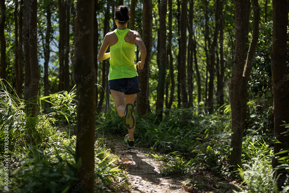 Fitness woman trail runner running in tropical forest Fitness woman trail runner running in tropical forest