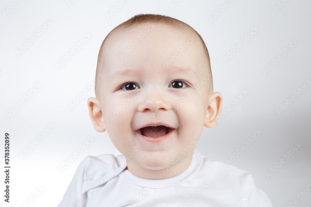 Portrait of a ten-month-old smiling baby on a white background