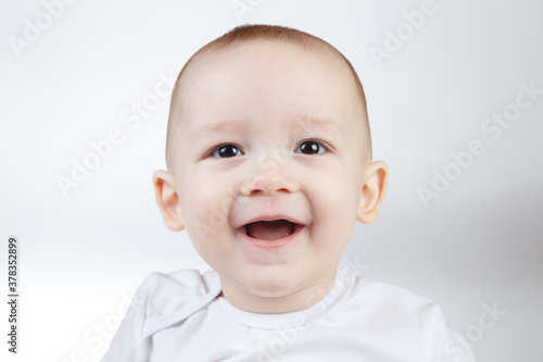 Portrait of a ten-month-old smiling baby on a white background