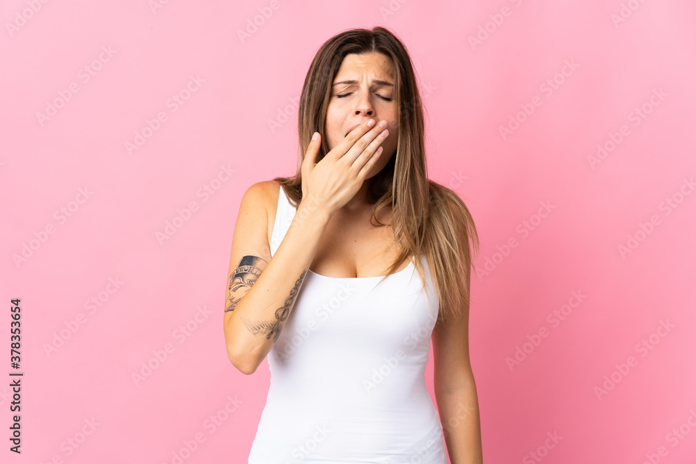 Young slovak woman isolated on pink background yawning and covering wide open mouth with hand Young slovak woman isolated on pink background yawning and covering wide open mouth with hand