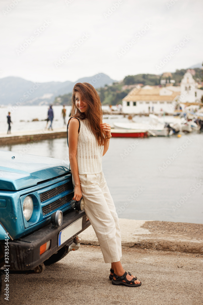 Cheerful girl standing near car outside. Traveler content. Cheerful girl standing near car outside. Traveler content.