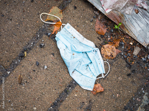 Used disposable face mask discarded in the street
