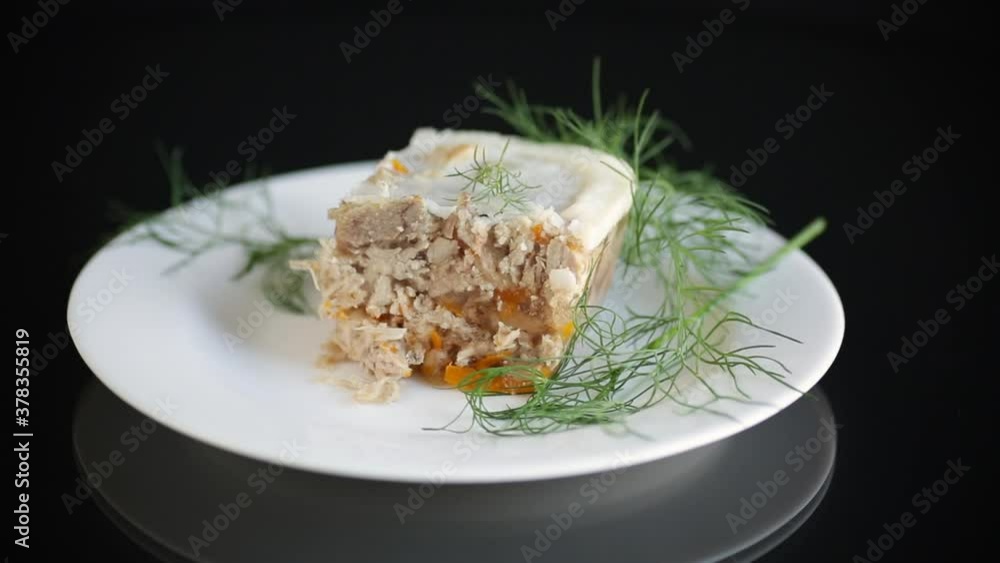 slice of chilled jellied meat in a plate on a black background slice of chilled jellied meat in a plate on a black background