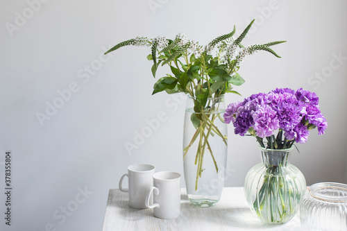 Bridal bouquets of lilac carnations in a four round glass vases different sizes as table decoration photo