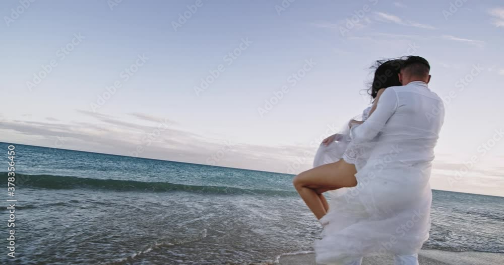 Happy and excited couple beside the seaside hugging each other and twist they feeling very excited and enthusiastic Happy and excited couple beside the seaside hugging each other and twist they feeling very excited and enthusiastic