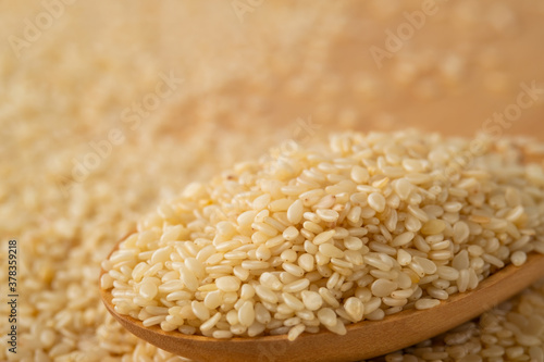 Closeup of white sesame seeds in wooden spoon.Selective focus