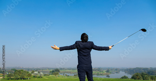 Back view of Young Asian CEO Businessman wearing suits playing golf at the golf course. Portrait of Asian businessman. sucess and happy time