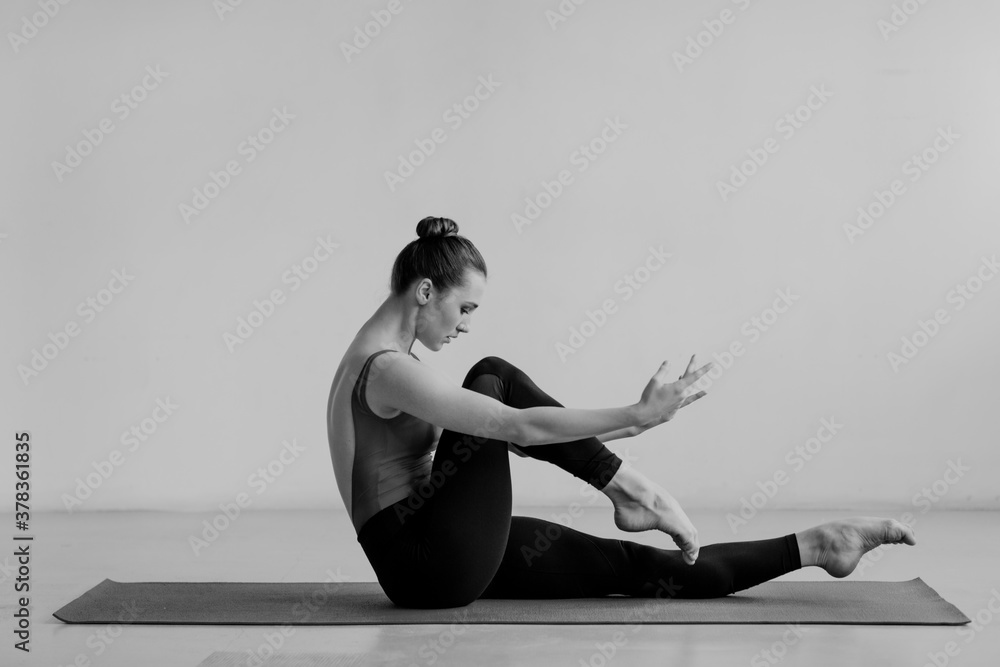 Young beautiful yoga woman is posing in studio.