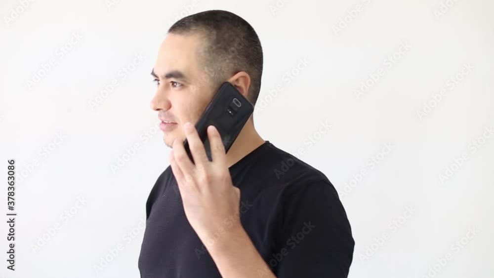 a man in a black t-shirt on a white background talking on the phone a man in a black t-shirt on a white background talking on the phone