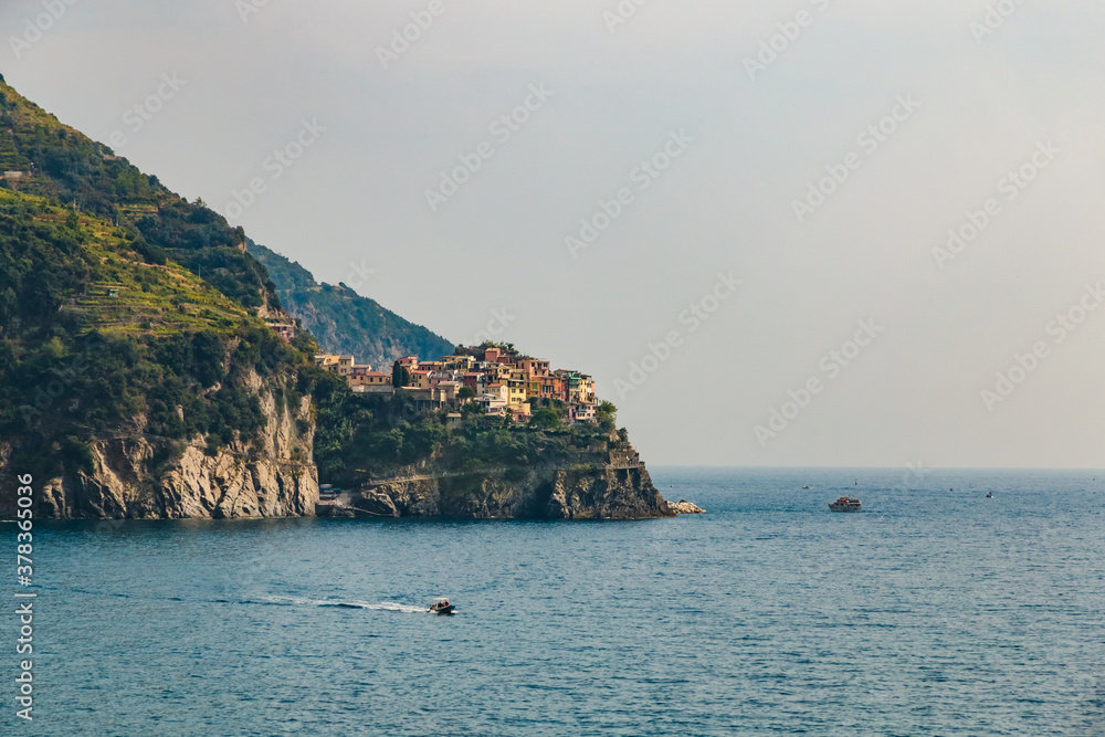 Lovely panoramic landscape view of Manarola, the second-smallest of the famous Cinque Terre towns. The small town with its colourful houses and vineyards on the cliff is a popular tourist attraction.