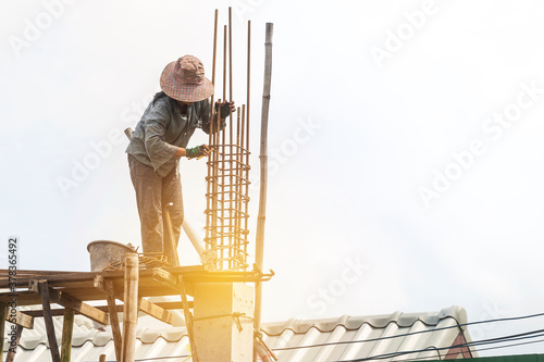 Female labor working at concstruction site, girl building house, work safety, construction business photo