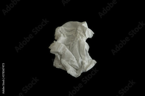 Used paper tissue on black background, top view