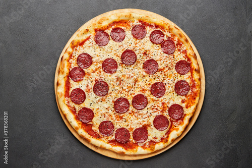 Delicious Italian Pizza pepperoni with mozzarella cheese and salami on dark background