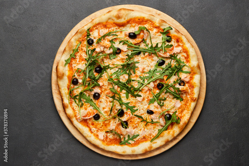 Delicious Italian seafood pizza on dark background