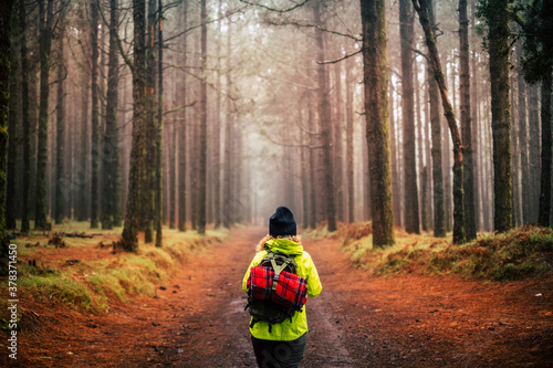 Active people in autumn and winter trekking outdoor leisure activity in the beautiful natural forest - wood and nature around and little humans in - woman enjoy the world traveling with a backpack photo