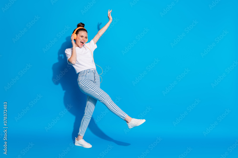 Full length body size view of her she nice attractive lovely pretty ecstatic cheerful cheery girl listening pop rock bass dancing having fun isolated on bright vivid sine vibrant blue color background