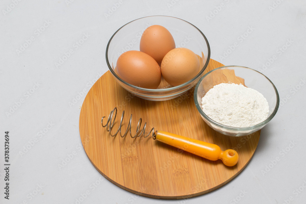 eggs and flour on white table background. basic baking background. eggs and flour on white table background. basic baking background.