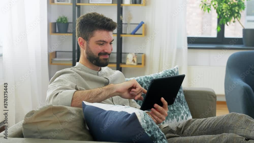 technology, people and lifestyle concept - happy man with tablet pc computer at home technology, people and lifestyle concept - happy man with tablet pc computer at home