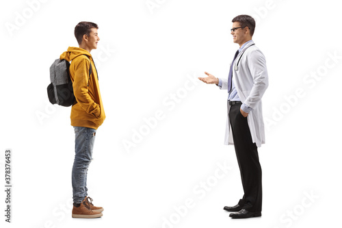 Full length profile shot of a teenager boy listening to a doctor
