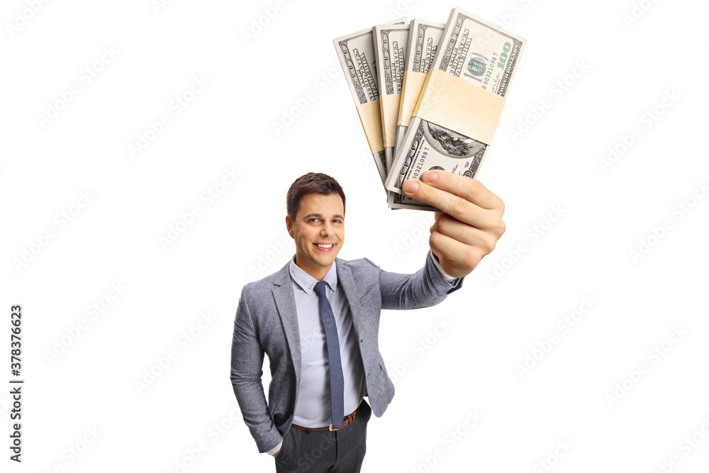 Professional young man showing stacks of money in front of the camera Professional young man showing stacks of money in front of the camera