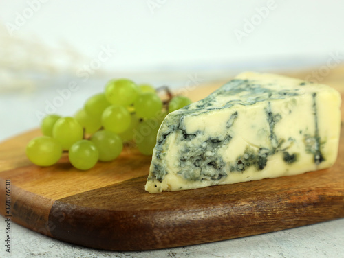 a piece of blue cheese served with grapes