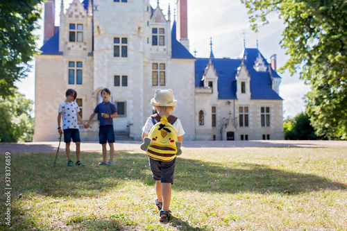 Children, walking together in park in front of castle photo