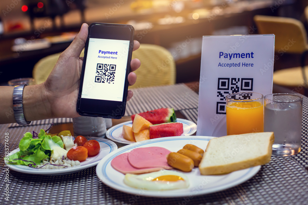 Hand using smart phone to scan QR code on tag with blurry food, dessert ...