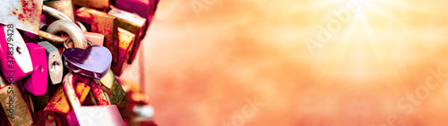 Lovers / Valentine's Day background banner panorama - Many colorful different Love padlocks / curtain lock illuminated by the sun