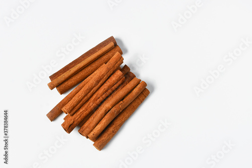 A top view image of several fresh cinnamon sticks on a white background.