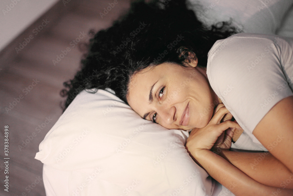 Young woman laying in bed on a pillow Young woman laying in bed on a pillow
