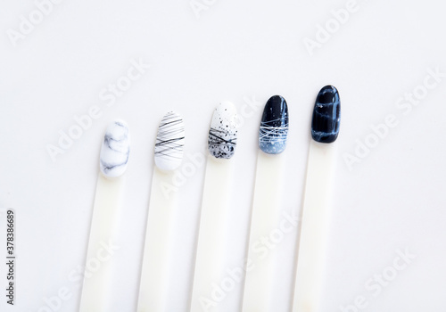 nail samples with black and white manicure design laid out in a line