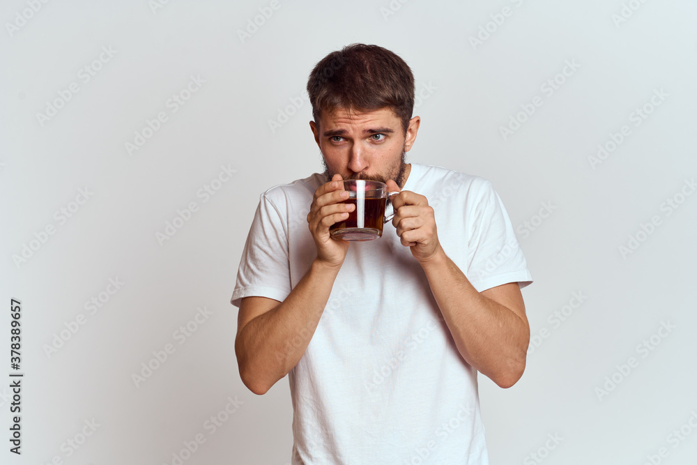 man with a cup of tea in a bag on a light background Hot drink cropped view model man with a cup of tea in a bag on a light background Hot drink cropped view model