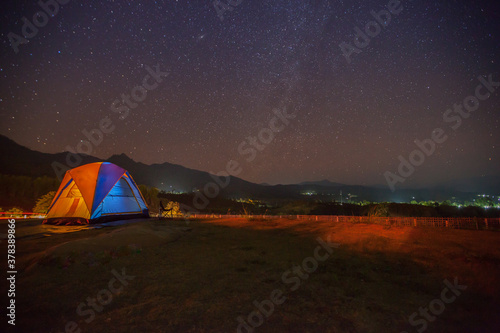 A star at nigh sky with cloudy with camping tents