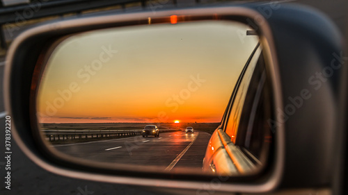 reflection seen through car side mirror - sunset