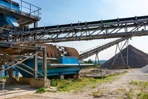 Cement mill sand dewatering machine and machine for transferring gravel, spoil for transport belts on blue sky at an industrial cement plant.