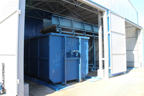 Blue waste containers in a large hangar