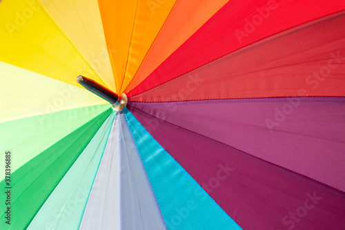 A multicolored rainbow umbrella, photographed close-up.