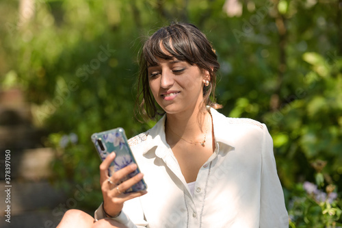 young woman using a phone in a park