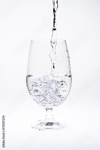 Pour water in glass isolated on white background.