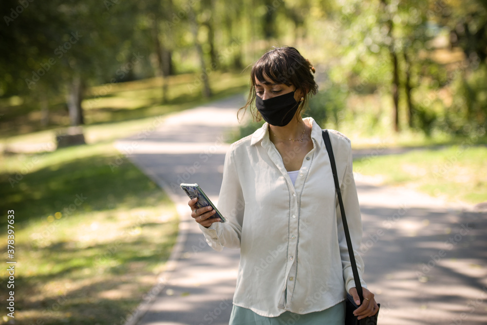 young woman protecting herself of covid with a mask in a park young woman protecting herself of covid with a mask in a park