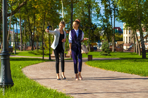 Two young girls walking in a summer park