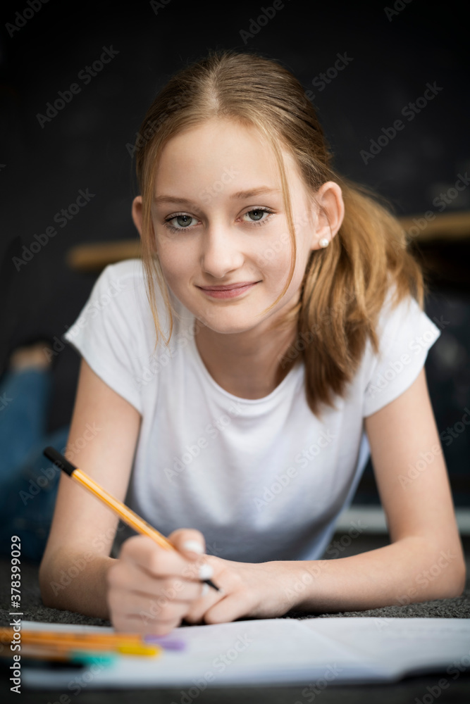 Girl lying on carpet and learning at home Girl lying on carpet and learning at home