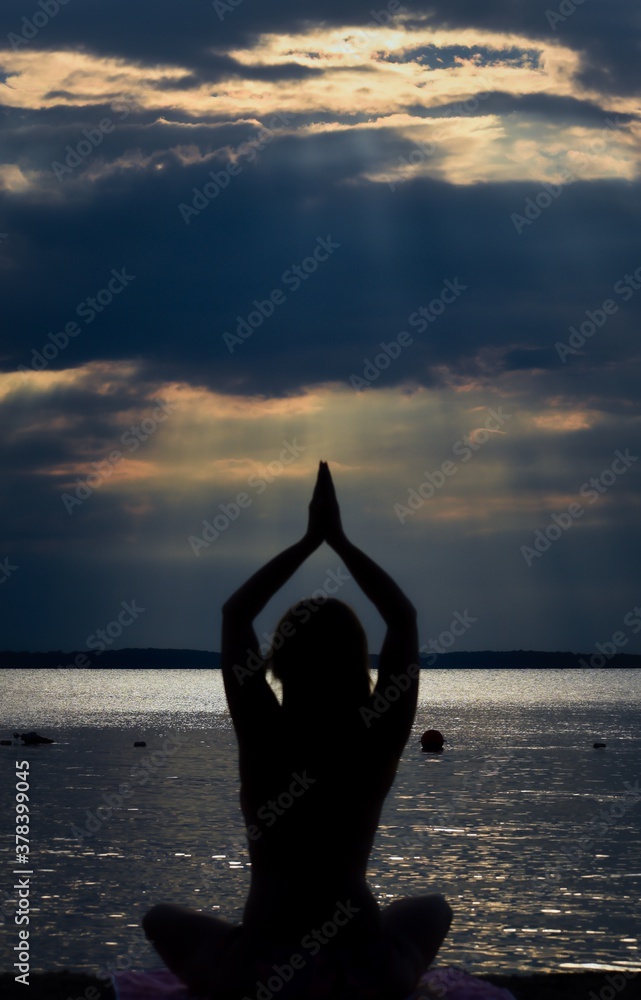 silhouette of a person doing yoga at the beach
