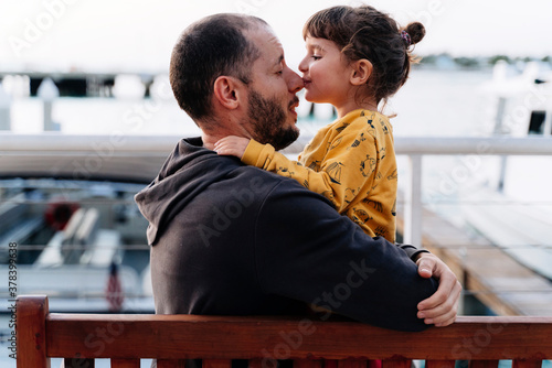 Father embracing while daughter kissing him on nose in city photo