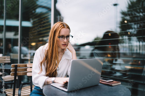 Serious woman with laptop working on project