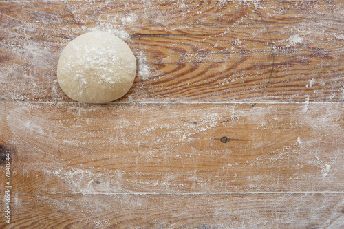 Dough and flour on a wooden board