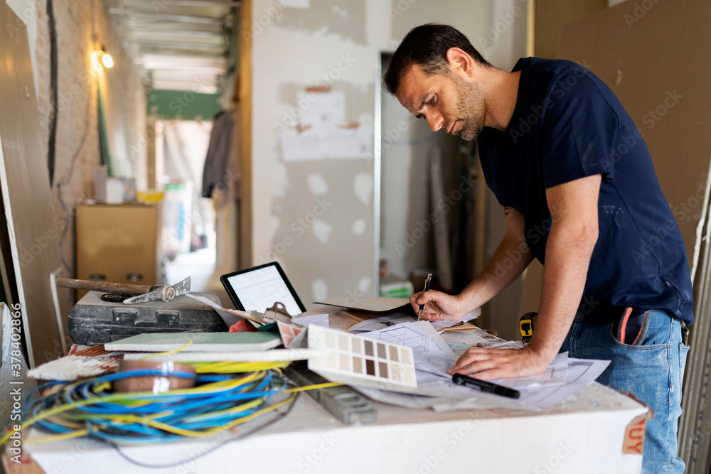 Man working on construction plan and colour swatch Man working on construction plan and colour swatch