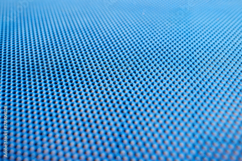 Blue plastic background with holes. Manufacture of plastic products with various textures and patterns.