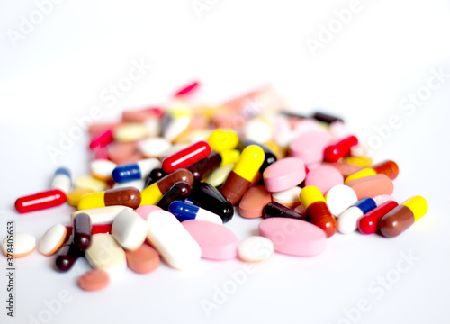 pile of medicine pills tablets capsules in white background