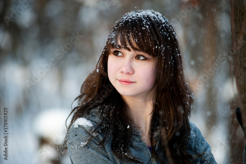 Close-up Portrait of a young beautiful happy smiling woman. Model posing on the street. The concept of winter holidays